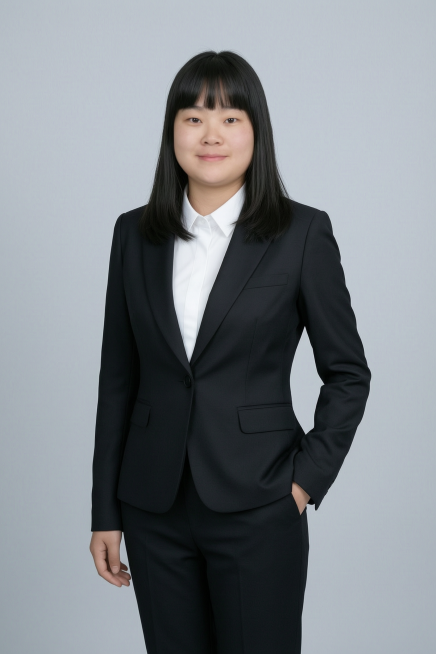 基于原图人物生成商务形象照，人物身穿黑色亚面精纺面料西装外套、黑色亚面精纺面料西裤，内搭白色衬衫，背景为简约冷调浅灰色纯色背景，背景光线均匀柔和，呈现均匀柔和质感，极简干净，强化色彩对比的高级感。采用预览效果