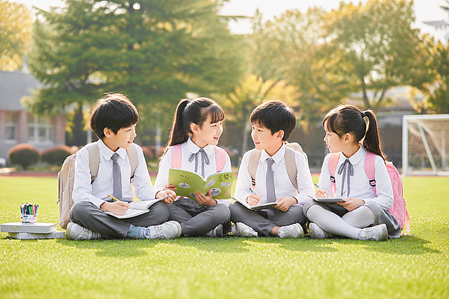 参考图片风格，重新生成四位小学生坐在校园草坪上学习交流的画面