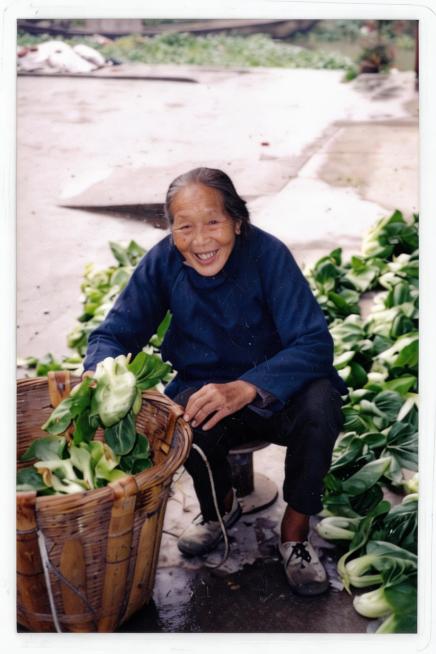生成竖版近距离高清5寸照片，保留老人和青菜的核心内容，裁剪放大人物面部区域，提升照片清晰度和画质，保留原照片怀旧真实风格预览效果