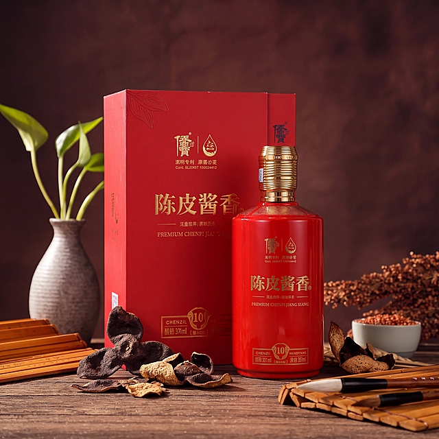 参考第一张图的中式复古暗调白酒产品摄影风格，将画面中的酒替换为第二张图中的红色瓶身的陈皮酱香酒及其红色礼盒，重点突出礼盒装，礼盒和酒瓶摆放在画面中央，木质桌面上摆放干陈皮作为点缀，背景为深棕色暗调质感背景，整体氛围高端典雅、有质感，符合抖音平台产品宣传调性，专业商业产品摄影，柔和暖光，景深虚化背景