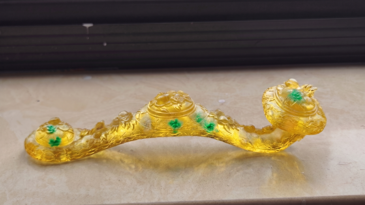 将玉如意整体调整为通体黄色，只在内部添加几点棉絮状的翠绿色纹理，保留雕刻纹理和通透材质预览效果