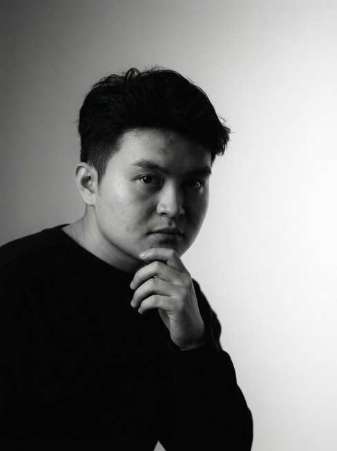 将上传的照片转换成高分辨率的黑白肖像艺术作品，采用编辑类和艺术摄影风格。背景呈现柔和渐变效果，从中灰过渡到近乎纯白，营造出层次感与寂静氛围。细腻的胶片颗粒质感为画面增添了一种可触摸的、模拟摄影般的柔和预览效果