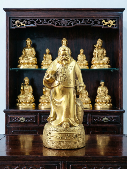 保持这个金色一本万利财神雕像主体不变，更换为深色佛龛展示柜新背景，3:4比例预览效果
