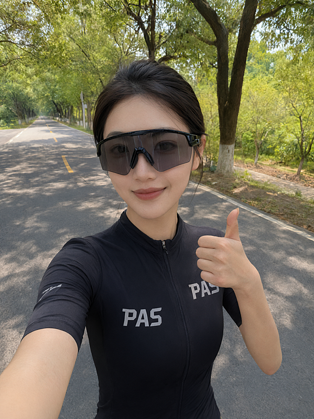 在保持原图所有元素不变的基础上，将女生佩戴的黑色运动太阳镜的镜片颜色略微减淡，提升一点透明度，同时去掉镜片表面的环境反光，使镜片看起来更干净通透。眼镜的几何形状、镜框样式、材质、人物、服装、背景、光影、画质等所有其他细节完全保持不变。