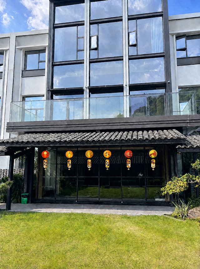 将每个灯笼上方悬挂的红绳稍微缩短一点，灯笼整体向上提升一小段距离，使灯笼离屋檐更近一些。保持灯笼的大小、样式、颜色、图案、排列顺序不变，保持原图建筑、草地、天空等所有环境元素不变，光影自然，真实感强。