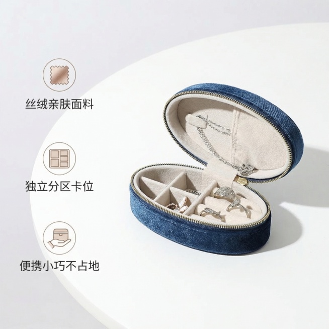 基于原图生成第二张藏青丝绒椭圆形首饰收纳盒的1:1电商主图，整体风格简约唯美，干净明亮。收纳盒开启状态展示内部分区结构，放在纯白色简约桌面上，柔和自然光突出内部结构设计。画面左侧垂直排列三个卖点，每个预览效果
