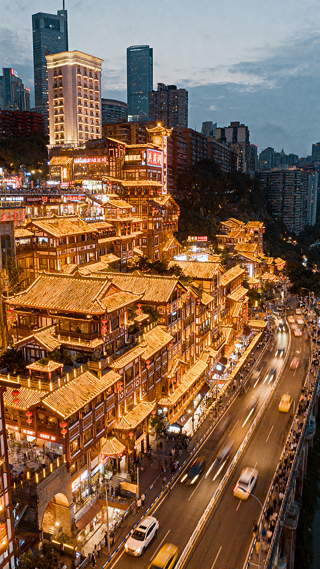 重庆洪崖洞夜景，依山而建的吊脚楼建筑群灯火辉煌，远处嘉陵江波光粼粼，航拍视角，繁华热闹，巴渝传统建筑特色，唯美治愈vlog风格
