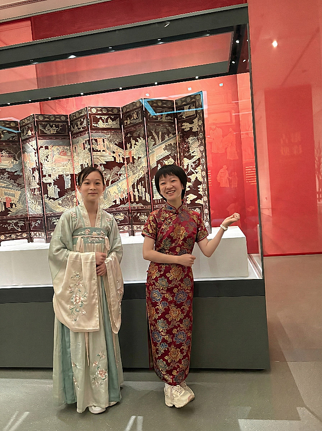 将图中俩人的衣服换为适合背景的传统服装，注意俩人均为女生