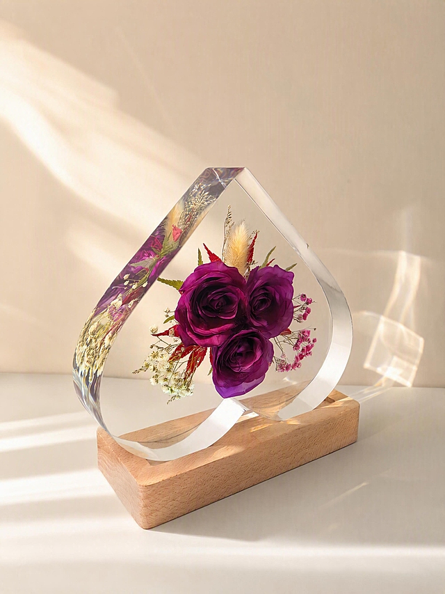 产品为心形树脂干花摆件，包含心形透明树脂块和原木底座，干花为三朵深紫色玫瑰搭配狗尾草、红叶、白色满天星和粉色满天星。保持产品主体物理结构绝对不变，不改变产品结构，产品中每张图只出现一次。树脂部分必须清亮透明犹如玻璃，画面干净无浮尘物。放置在浅白色哑光台面上，侧光拍摄，阳光从侧面照射，增强透光感，阳光透过透明树脂形成美丽的光斑。背景是浅米色墙面，干净简洁。侧视角度构图，展示产品侧面透光质感。柔和暖调阳光，低对比度。商业级4K摄影，画面通透干净，符合国内电商种草风格。保持3:4画面比例。负向词：西方面孔,金发,深眼窝,雀斑,杂乱房间,死黑阴影,硬光,乡村风,高对比度,欧美妆容,变形,扭曲,穿模,重叠,比例失调,浮尘,脏污,树脂浑浊,多个产品