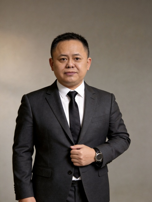 基于参考图生成形象照，其他保持不变，只修饰脸部：去除脸部斑点，均匀肤色，增加自然美颜效果，保留真实皮肤质感，不要过度磨皮，整体自然协调。深灰色精纺羊毛混纺西装外套+白色衬衫+深灰西裤，佩戴领带手表，站预览效果