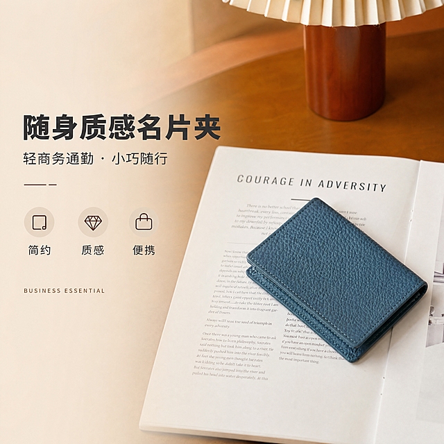 [商品] 使用【图2】深蓝色荔枝纹牛皮名片卡包；保留短款对折造型、荔枝纹头层牛皮、深蓝色、缝线细节、统一尺寸比例；自然理顺皮面，增强荔枝纹肌理与缝线精致度，不改变版型和结构。
[画面] 目标：第2张设计理念·轻商务通勤风格主张。构图：左文右图，右侧卡包斜放于杂志书页上，左侧留白放文案，主体占画面45%。景别：中景。前中后景：前景米白杂志纸张纹理，中景卡包主体，后景虚化棕色台灯底座与木质桌面。阅读动线：从左标题到右产品。
[视觉] 套系策略：风格=1688轻商务高级感商业摄影；标题字=现代无衬线粗体（思源黑体Heavy）；正文字=简洁无衬线体（思源黑体Regular）；主色=暖棕驼色；背景延展=基于暖棕驼色做深浅层级、同色渐变和细腻木纹/纸张质感；强调色=深焦糖色，仅用于小面积图标、引线和标签；标题色=深炭灰；正文色=中暖灰；组件=圆角浅底信息卡、细线引线、小标签；光影=左前侧暖柔光，柔和自然阴影。
[文字] 左侧主标题「随身质感名片夹」（7字），副标题「轻商务通勤 · 小巧随行」，下方3个风格关键词：简约、质感、便携。配小号英文装饰「BUSINESS ESSENTIAL」。文字横排，层级清晰。
[规格] 图片比例1:1方版，分辨率4K，quality=medium。避免变形、错字、文字过小、冷蓝/蓝灰背景、卡包颜色改变、版型失真、极限词。