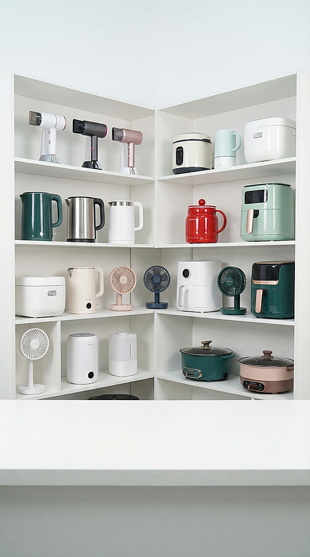 干净明亮的小家电直播间背景，白色简约多层货架，货架上整齐摆放吹风机、电水壶、电饭煲、空气炸锅、小风扇、加湿器、电煮锅等小家电，红色电煮杯放置在后排货架上，不保留前景主体的电源线和说明书，整体明亮整洁，现代简约风格，无多余装饰，无摄影灯，无补光灯，无直播灯具，纯背景场景，高清实拍。整体漫射柔光，画面明亮干净，低对比度，阴影极淡柔和。