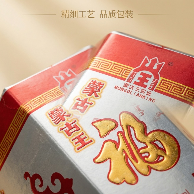 主图主题：产品细节特写展示 氛围风格：简约大气，细腻质感，专业品质 画面元素：特写放大蒙古王福酒包装盒上的金色福字和品牌标识，突出烫金工艺细节，包装盒主体部分自然延伸，背景为纯净浅米金色，铺满全屏，特预览效果