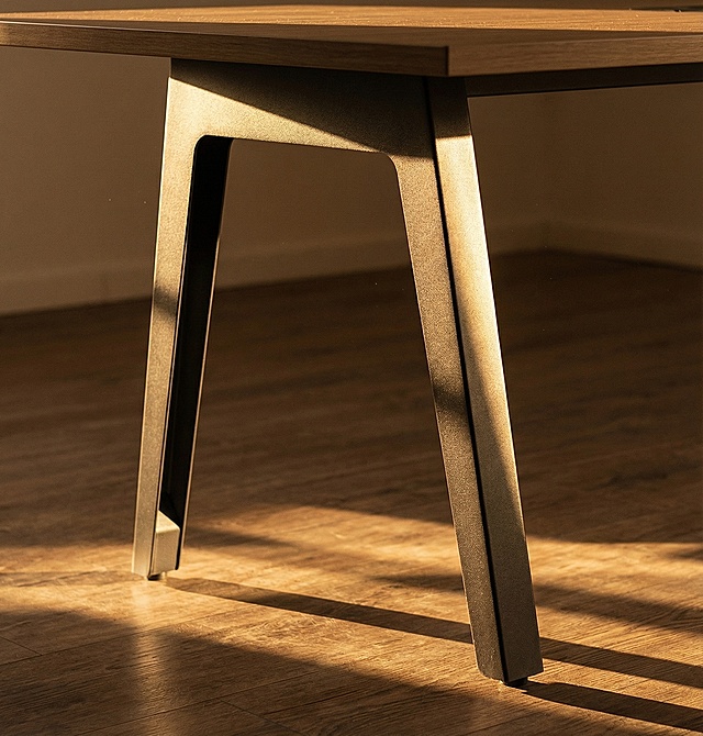 特写放大会议桌脚架，阳光勾勒桌腿，整体色调温馨和谐，电影质感，角落光影交织，温暖氛围拉满，超高清画质