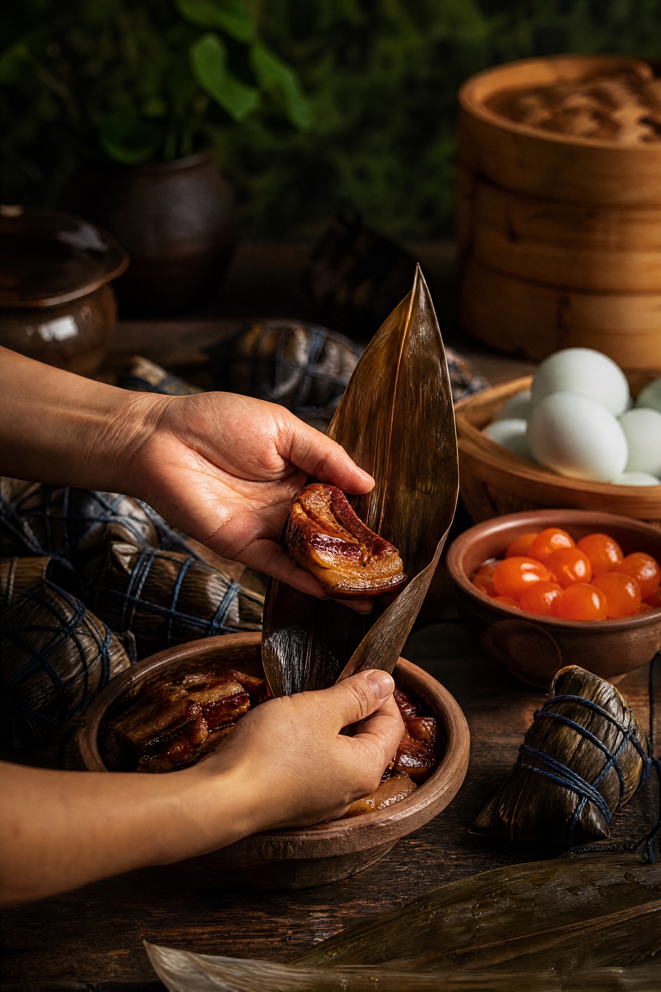 画面聚焦于一双手正在准备包粽子的瞬间：左手托着一方油汪汪的酱红… - 图片创意预览
