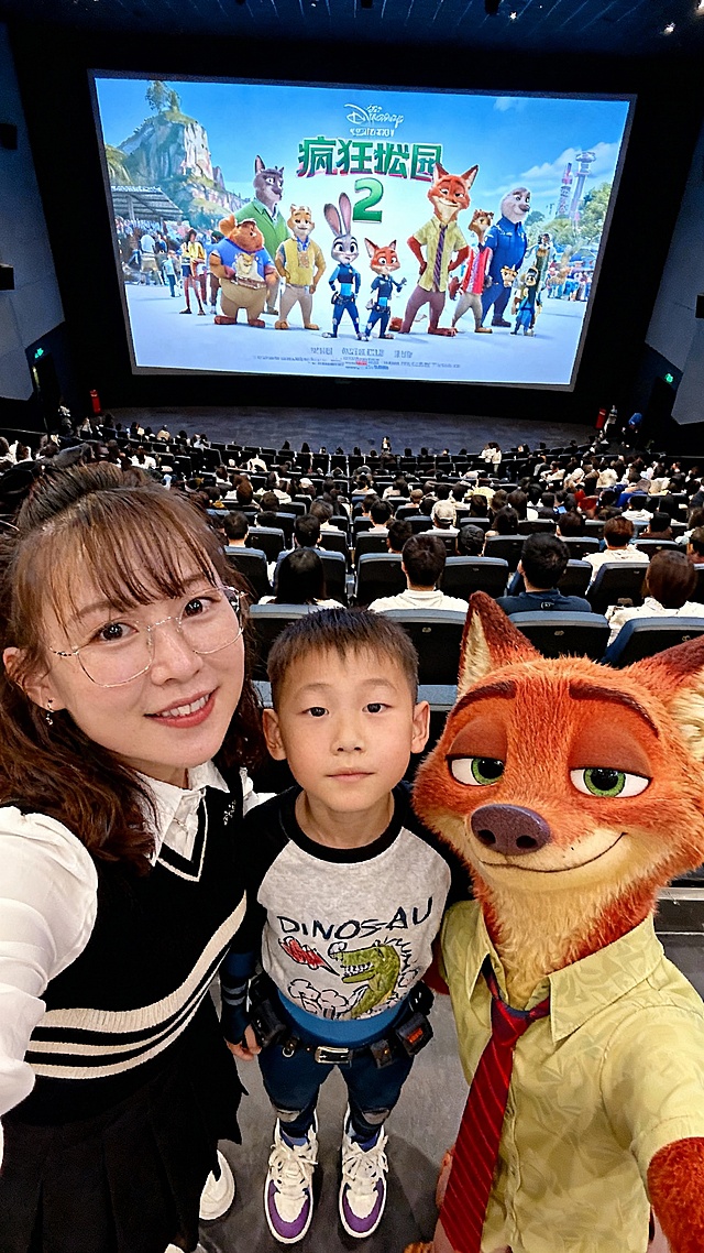 卡通感十足的软3D风场景，拟人化动物角色与真人互动，营造出欢乐温馨的节日氛围，视觉风格明亮活泼，创意融合现实与动画世界。