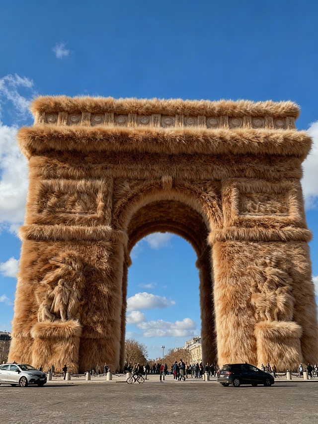 毛发生长风包裹凯旋门，重拟物与超现实主义碰撞，实景感中透出趣味冲击，体积感十足的绒毛巨构颠覆经典。