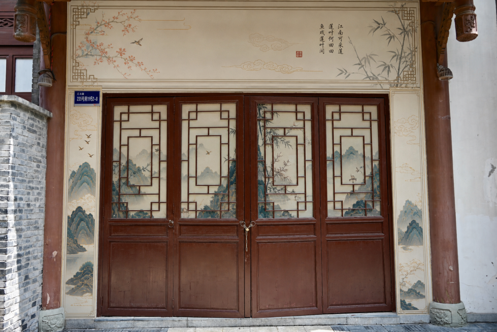 对该空铺进行包装设计：1.大门上方及两侧周边白墙区域用带国风画面的板子整体包装美化；2.在四个大门玻璃窗内侧从内部贴统一风格画面遮挡美化；整体打造适合打卡的国风点位，和周边古建风格协调，真实实景效果图预览效果