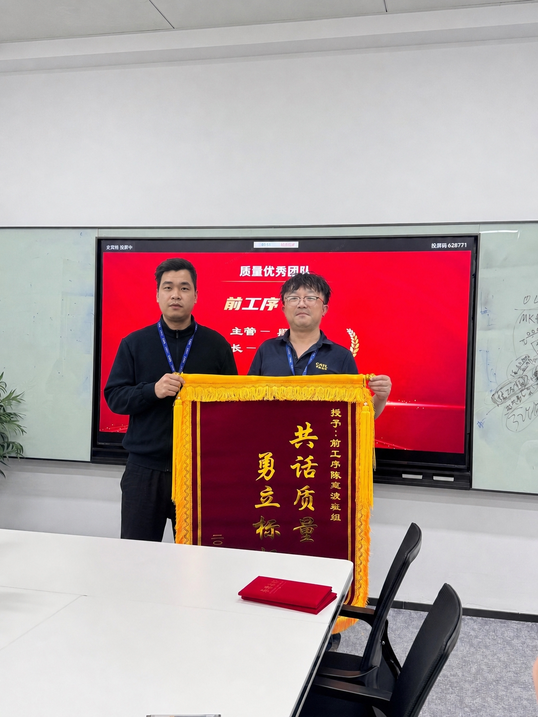 将图二中的男子合成到图一画面中，形成两人共同手持锦旗的合照效果… - 图片创意预览