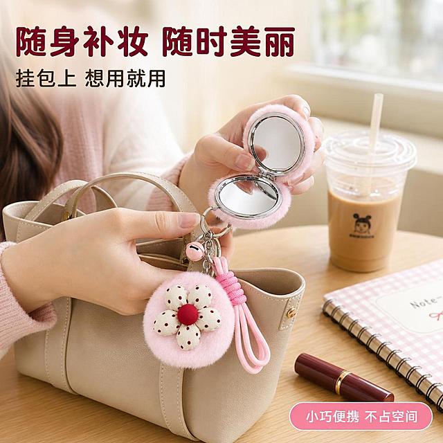 [主图-4] 毛绒花朵折叠镜真实使用场景图，展示挂包与手持补妆场景。
[氛围风格] 日常甜美少女风，生活化场景，自然真实；
[画质] 商业摄影质感、光线柔和自然、产品清晰真实、画面干净有氛围感。
[元素] 画面展示一位年轻女性（东亚面孔，甜美气质，浅色系穿搭）的局部手部与包包场景：一只手从米色皮质托特包中拿出粉色毛绒花朵折叠镜，镜子打开正在补妆，手部姿态自然。包包放在浅木色桌面上，旁边有一杯奶茶、一本笔记本、一支口红等日常物品。背景是明亮的室内咖啡馆或书桌场景，窗外有柔和自然光。**保持产品外观（即物理结构、材质质感、颜色、花朵造型、铃铛挂绳、金属扣、双面镜面结构）与输入产品图保持绝对一致，杜绝任何变形和色差，精细化处理**。商品主体占比约40%，作为场景核心元素；画面满屏无边框。
[光影] 自然窗边柔光从右侧洒入，形成温暖明亮的主光，左侧柔和补光，整体氛围温馨治愈，光影自然有层次。
[配色] 主色奶白色+柔粉色；辅色浅木色、米色；强调色酒红。
[视角构图] 俯视微侧视角，桌面场景完整呈现，镜子与手部动作为视觉焦点；前中后景分层，景深感强，生活气息浓厚。
[文字版式] 左上负空间左对齐留安全边距。大字主文案「随身补妆 随时美丽」，酒红色最大号粗体圆润字体；辅助短句「挂包上 想用就用」，约半高、深棕色。底部右侧小标签「小巧便携 不占空间」，粉色圆角标签白字。画面禁止出现多余的手、多余的手指、畸形手、融合手指、手部扭曲、肢体穿模、人物面部扭曲、关节反折。
[输出要求] 1:1 比例，2048px*2048px，2K分辨率，文字清晰锐利，画面超高清商业摄影质感。
[负向提示词] 变形，文字错乱，产品图模糊，背景杂乱，水印，电商平台Logo，多余的手，多余的手指，畸形手，融合手指，手部扭曲，肢体穿模，人物面部扭曲，关节反折。