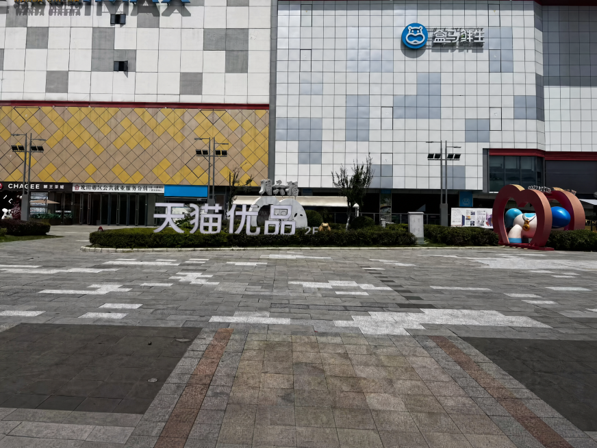 修改图片，将图2中的“KK桌球”字样替换为“天猫优品”，然后把替换好的“天猫优品”标识放置到图1红框内的草坪上，保持整体场景自然协调，光影和视角与原图一致预览效果