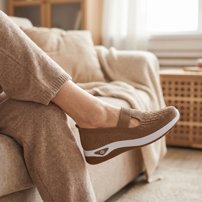 [Main Image 5] Elderly female model wearing slip-on fly-knit casual shoes, sitting on sofa at home,预览效果