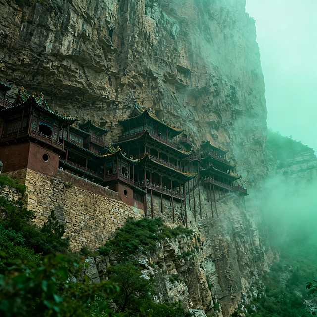 山西悬空寺历史建筑图片，悬挂于恒山峭壁之间，独特木结构空中楼阁，晨雾缭绕，自然风光与奇巧建筑结合，写实摄影风格，青绿色调，展现千年古建奇险特色