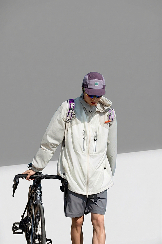 将背景替换为室内纯灰白色背景，保持人物和服装不变，人物光线自然，使用正面打自然光，保持人物服装版型不变