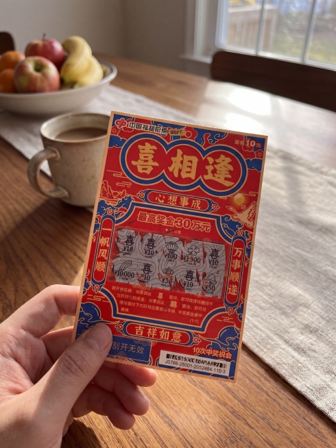 保持刮刮乐红包的结构、图案、文字内容完全不变，将背景更换为家居餐桌场景，保持手机真实拍摄质感，光影自然预览效果