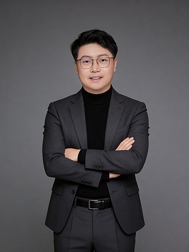 参考第一张图保留人物脸型､发型､年龄等特征生成职场形象照,参考第二张图人物占位和比例,标准焦段50mm,F/4光圈(F/2.8-F/4区间),平视视角(镜头与人物视线齐平);人物占画面70%,人物居中(居中构图),位于画面中心,为视觉聚焦点,入境范围头部及以下至臀部下方10cm(半身像);左右留少量背景空间;头部与画面顶部保留5%空间;头部发型完整,头肩比例协调;身穿修身精纺羊毛混纺面料的深灰色西装外套(含5%桑蚕丝提升柔光质感),平驳领(商务感正式感),左胸袋无口袋巾(简化高级感),西装下摆自然垂度;内搭黑色中领紧身针织上衣,下装精纺羊毛混纺面料的深灰色高腰直筒西裤(面料同西装),搭配黑色哑光头层牛皮皮带(宽1.5cm),带扣为长方形拉丝黑色金属(1.8cm×2.5cm);呈正面抱胸的自然站立姿态:左臂搭于右臂上方,肩颈自然松弛下沉,姿态自信从容｡正式严谨专业稳重,身形匀称,姿态端正｡发梢微微修整干练大气,主体锐利,影棚侧光布光(主光来自画面前方),明暗过渡柔和,背景光线均匀,强化色彩对比的高级感｡哑光简约中深灰色纯色背景(呈现均匀柔和质感),极简干净;32K画质超高分辨率､细节清晰,整体风格雅致､兼具现代精致感;肤质精细化处理;眼神直视镜头,目光坚定且澄澈,表情自然.嘴角上扬;肌肤白皙透亮,柔光提亮,细腻无瑕,通透高级,干净清透肤质,肤色均匀,柔光美白细腻陶瓷肌肤,自然提亮,光影柔和通透水光肌,肤质细腻平滑干净哑光肤质,无油光无暗沉,肤色均匀提亮;杰作,最佳画质,超高细节,写实摄影,中近景人像,面部清晰,五官精致,皮肤细腻通透,白皙清透皮肤,干净肤色,健康肤色,无蜡黄,无暗沉,无黄皮,柔光,正面补光,面部光线均匀明亮,无浓重阴影,冷色调白平衡,画面干净清新,色调明亮,对焦清晰,肤质细腻,高清皮肤细节;面部光比1:1.5,4800K中性光,微微修饰脸型,肤质哑光细腻,面部雾面柔光,轻透裸肌感,真实毛孔纹理,32K画质,去除人物之外的所有元素｡