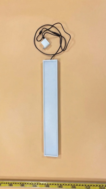 将图片的背景替换为浅杏色，保留原有的长条形灯具、黑色电源线、白色充电器和底部黄色卷尺，主体物品保持原样不变预览效果