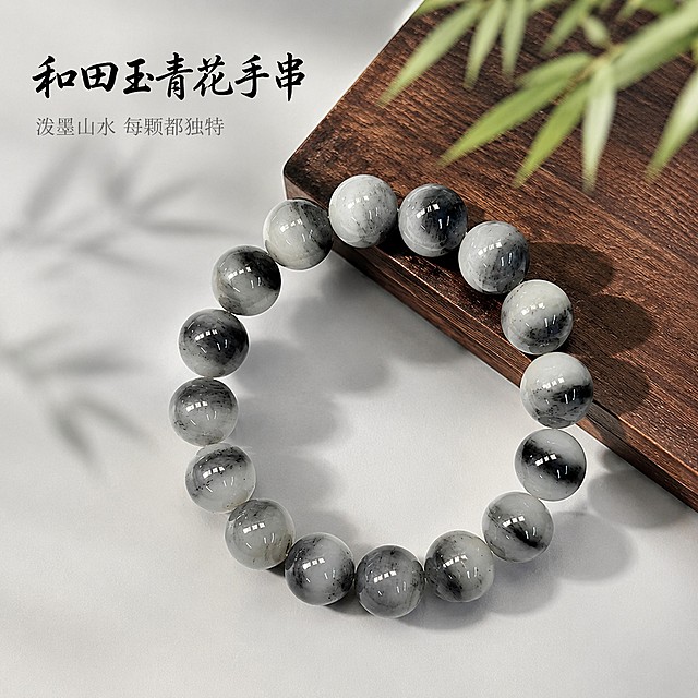 [主图-1] 和田玉青花手串首图展示；氛围风格为国风禅意高级质感；画质要求商业珠宝摄影质感，光线柔和通透，产品清晰真实，画面干净高级；画面中，和田玉青花手串居中展示，保留黑白交织独特纹理，每颗珠子纹理各不相同如流动写意画，木质底板搭配竹叶虚影作背景，浅灰白色干净背景衬托产品。保持和田玉青花手串外观、珠子大小、纹理颜色与输入产品图绝对一致，杜绝任何变形和色差，精细化处理。商品主体占比严格控制在65%左右，画面满屏无边框；光影采用顶侧柔光作主光，勾勒珠子圆润轮廓，背景轮廓光勾边突出产品立体感，玉石表面保留温润高光，暗部干净有层次；配色主色调为黑白灰，搭配原木棕与竹叶浅绿作点缀，整体素雅干净；视角构图为俯视45°拍摄，产品完整居中展示，景深适中；文字版式为左上负空间左对齐留安全边距，大字主文案写"和田玉青花手串"，黑色书法字体，下方辅助短句写"泼墨山水 每颗都独特"，缩小字号浅灰色，文字不遮挡产品主体；比例分辨率为1:1 比例，4k 分辨率；要求文字清晰锐利，超高清；负向提示词为变形，文字错乱，产品图模糊，背景杂乱，水印，电商平台Logo，过度修图改变纹理