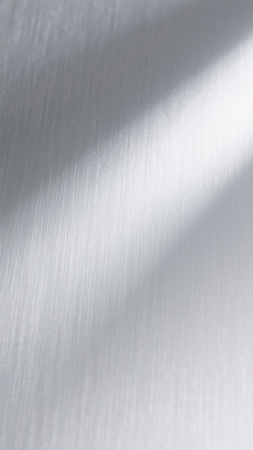 一张具有高度金属质感的银色背景，表面呈现细腻均匀的拉丝纹理，整体色调为银白色，光线从左上角斜向右下角柔和照射，形成自然的明暗过渡和轻微的高光区域，展现出不锈钢或铝合金材质特有的冷冽、光滑且略带工业感的视觉效果，无任何文字、图案或其他元素干扰，纯粹作为背景使用。预览效果