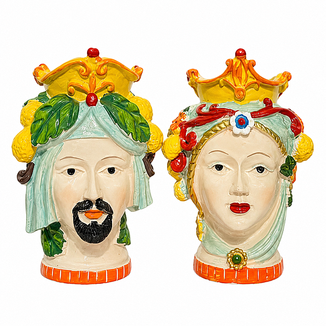 Amazon compliant white background product main image. Pure white #FFFFFF background, no shadow, no text, no scene. Two Sicilian Moorish head ceramic vases (male and female pair) centered in the frame, product occupies 85%+ of the image. The male head has light blue turban, black beard, yellow crown with red ornaments, yellow lemon decorations and green leaves on both sides. The female head has red headband with blue gem ornament, red lips, yellow crown, yellow fruit decorations on both sides. Both have orange-red striped bases. Keep product appearance, physical structure, material texture, color and details exactly the same as the input product image, no deformation, no color difference, fine ceramic texture with glossy glaze finish. Front view, both vases fully visible, no cropping. Ultra high definition commercial product photography quality, sharp details, clean edges. Negative: deformed, blurry product, messy background, watermark, e-commerce platform logo, text, shadows, props.