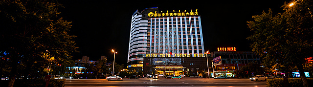 将这张鄂尔多斯铁牛国航大酒店夜景图片整体压缩适配到360*100像素画布，保留完整酒店建筑和顶部发光酒店名称文字，横版构图，保持原有清晰画质和城市夜景灯光氛围