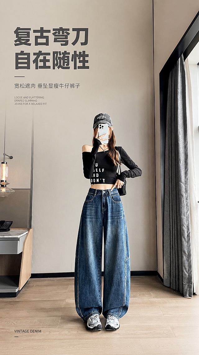 [第1屏] 详情页头图，牛仔弯刀裤穿搭宣传海报，本屏使用【图1】作为商品主体。
[标题版式] 简约现代字体，左上留白排版，主标题粗字重，副标题细字轻装饰，英文小字点缀，整体简约大气。
[氛围/风格] 简约时尚，实景氛围感，商业摄影质感，高级干净。
[元素布局] 模特穿搭整体位于画面中下区域，占比约70%，左上预留文字区域，保留原图简约室内场景背景，突出牛仔裤廓形、弯刀版型与整体穿搭效果，裤子颜色、结构与输入产品图保持一致。
[光影质感] 自然柔和顶光，人物身体下方自然投影，明暗层次清晰，裤子水洗纹理清晰可见。
[配色色系] 全局底色 #F0ECE8，主色复古牛仔蓝，辅助色米灰背景、深灰文字。
[视角构图] 平视正面视角，产品穿搭为视觉中心，阅读动线左上标题→中下主体→底部留白。
[文字版式] 左上文字区域排版：主标题「复古弯刀 自在随性」，副标题「宽松遮肉 垂坠显瘦牛仔裤子」，左下角小字英文装饰 "VINTAGE DENIM"；文字不遮挡主体，清晰可读。
[比例分辨率] 9:16竖版比例，4K分辨率，文字清晰可辨，高清画质。
[负向提示词] 裤子变形，颜色偏差，文字错乱，文字过小，缺件错件，水印，背景杂乱，结构错误