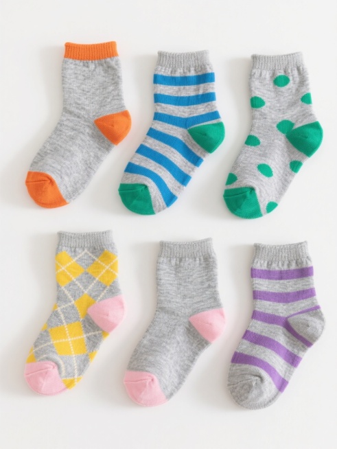 白色纯色背景，6双不同设计的儿童短袜规整排布成系列集合，保持与原图一致的高清写实摄影风格，清晰展现针织纹理质感，每双袜子均采用类似的灰色主体搭配彩色细节设计，第一双为灰色配橙色袜口和袜头，第二双为灰色配蓝色条纹，第三双为灰色配绿色波点，第四双为灰色配黄色菱形图案，第五双为灰色配粉色脚跟和脚尖，第六双为灰色配紫色条纹，整体光线明亮柔和，阴影自然，构图对称平衡，视觉层级清晰，突出袜子的材质感和色彩……预览效果