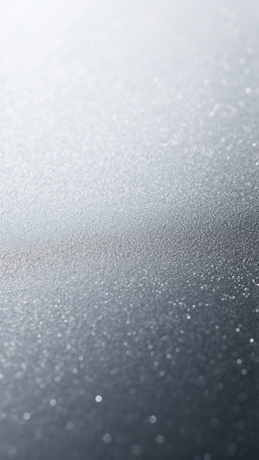 一张具有细腻磨砂质感的银色背景图片，整体呈现从顶部的银白色向底部的深灰色自然过渡的渐变效果，表面布满均匀且精致的细微颗粒纹理，不同区域的纹路在保持整体和谐的基础上展现出微妙的变化，部分区域纹路略粗形成轻微的肌理对比，光线从左上角柔和照射，使银色表面呈现出细腻的高光与阴影层次，营造出冷静、现代且富有高级感的金属质感氛围。预览效果