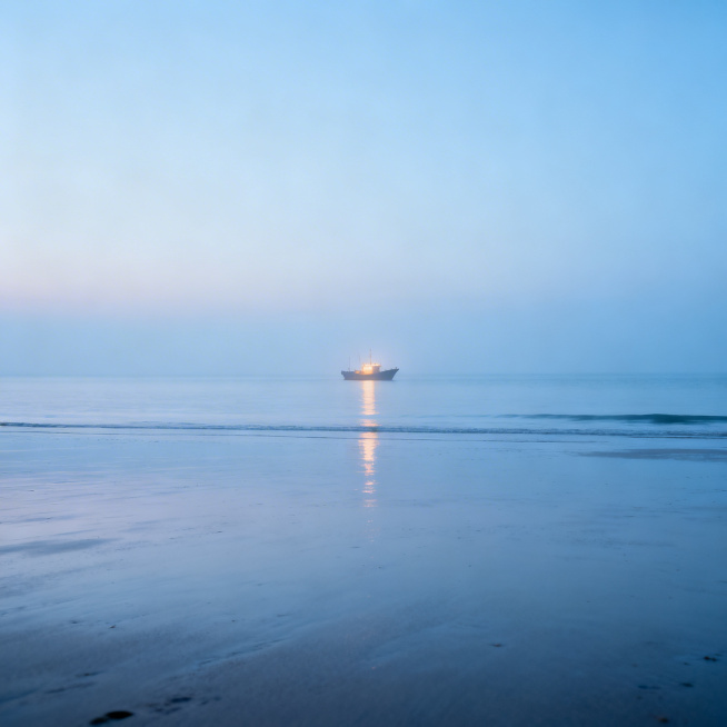 写实风景摄影，海边清晨时分，淡蓝色的天空澄澈柔和，海面平静无波，细腻的沙滩空旷干净，远处的渔船亮着微弱的暖光，整体氛围宁静治愈，空气湿润通透，光影柔和自然，细节细腻真实预览效果