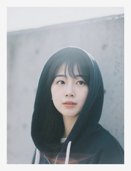 一个女生，灰色水泥背景，帽衫，大光圈，虚焦感，朦胧感，轻微过爆预览效果