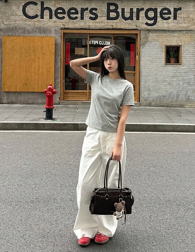 参考上传图片的构图，生成T恤电商商品展示图，模特穿着基础款T恤，休闲日常街景，突出T恤版型与质感，画面清晰有电商商品展示感