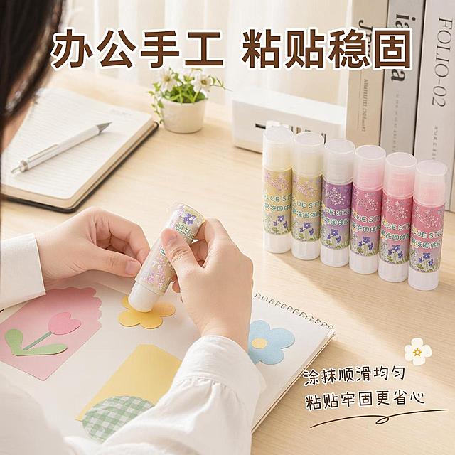 [第6屏] 办公场景真实使用演示。本屏使用【图1】产品展示手工粘贴操作。
[氛围/风格] 真实办公场景，自然温馨，生活化质感。
[文字版式] 顶部主标题「办公手工 粘贴稳固」，右下角标注核心卖点短句。
[元素布局] 桌面场景，亚洲女生手部操作，手持果冻固体胶粘贴手工纸张，产品放在桌面右侧，桌面点缀笔记本和笔，产品颜色外观与输入图一致。产品占画面约40%，手部操作自然真实。背景为浅木色办公桌面。
[光影质感] 左侧窗边自然光，光线柔和，桌面阴影自然，产品和操作动作清晰呈现。
[配色色系] 全局底色 #E8E4D6；木色桌面，浅白色纸张，保留产品本身多彩色系。
[视角构图] 略微俯视，操作场景居中，主体突出，阅读动线从上到下。
[比例分辨率] 1:1正方形比例，4K分辨率，高清画质，文字清晰。
[负向提示词] 手势变形，产品变形，颜色错误，场景杂乱，文字遮挡主体。