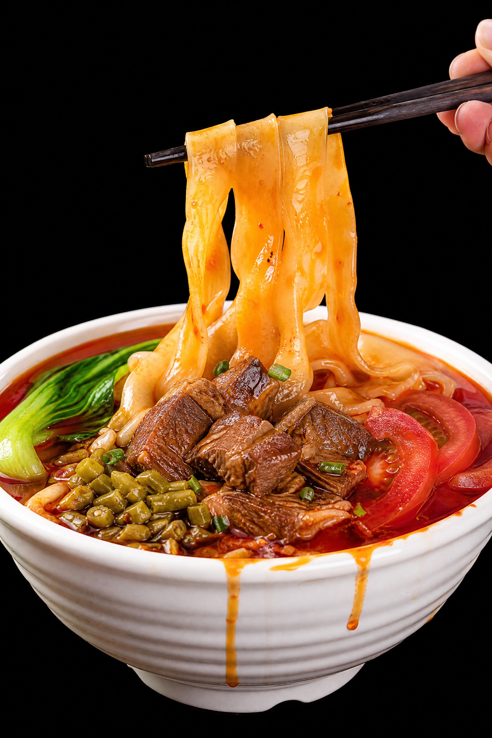 商业美食广告摄影，一碗红烧牛肉刀削面，右手持黑色木筷子夹起数根… - 图片创意预览