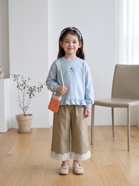 将图片1的浅蓝色卫衣和卡其色裤子儿童套装穿在图片2的小女孩身上，保持正确的比例，背景为简约韩系时尚基地，全身照，根据衣服样式搭配合适配饰，风格自然清新预览效果