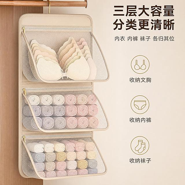 [主图-2] 主题：大容量分层收纳 满载展示。唯一任务：证明收纳挂袋能装、分类清晰、空间利用率高。
[统一基调] 淘宝/天猫 1:1 主图，简约家居品质风，暖白+米色+浅原木色为主，少量清透灰蓝点缀；标题字色深咖色，辅助字色中灰色，强调色浅金；字体为无衬线黑体，标题粗体大号，辅助字缩小50%以上；整体干净通透、秩序感强、温暖家居自然光。
[画面] 产品为米色三层网纱收纳挂袋，悬挂状态，三层隔层的拉链全部拉开，翻盖向外翻开，内部满载状态清晰展示。最上层整齐叠放多件文胸，中层整齐卷放多件内裤，下层整齐卷放多双袜子，每一层物品都排列紧密但有序，体现大容量。视角为正面略微俯视，产品主体占画面约65%，位于画面中央。背景为简洁的浅米色墙面+左侧局部浅木色衣柜侧板，环境干净不抢戏。画面右侧用三个简约图标分别对应三层，图标为文胸、内裤、袜子的简约线条图形，每个图标旁标注对应收纳品类。
[光影质感] 柔和均匀的家居棚拍光，正面主光+轻微侧逆光勾勒网纱边缘通透感，每层内部物品有自然层次阴影，米色包边质感细腻，拉链金属质感真实，整体明亮干净。
[配色] 背景浅米色+浅木色，产品米色+白色网纱，图标浅金色，文字深咖色+中灰色。
[文字版式] 画面顶部主标题粗体大字"三层大容量 分类更清晰"；主标题下方小字"内衣 内裤 袜子 各归其位"；右侧三个图标竖向排列，每个图标右侧配一行说明文字，字号为标题的40%。文字均放在背景空白区域，不遮挡产品主体。
[输出要求] 比例1:1，2048*2048，文字清晰，产品外观结构与输入图一致，每层内部物品整齐不杂乱，网纱通透可见内部。负向：变形、错字、模糊、物品杂乱溢出、产品穿模、悬浮、水印、平台Logo。