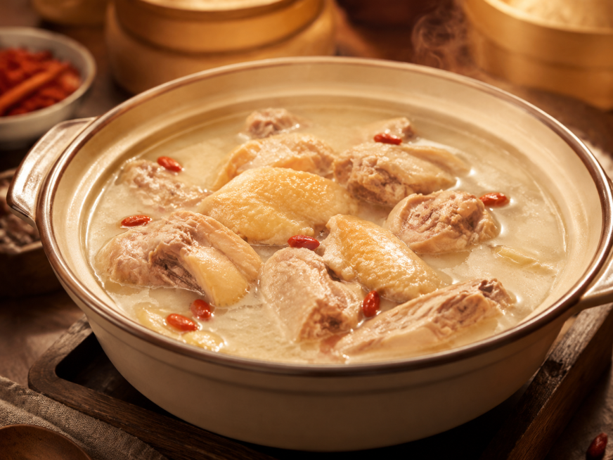 一锅滋补鸡汤，鸡汤呈乳白色，鸡肉切成块，汤里点缀着几颗枸杞，美食摄影，暖色调，诱人食欲预览效果