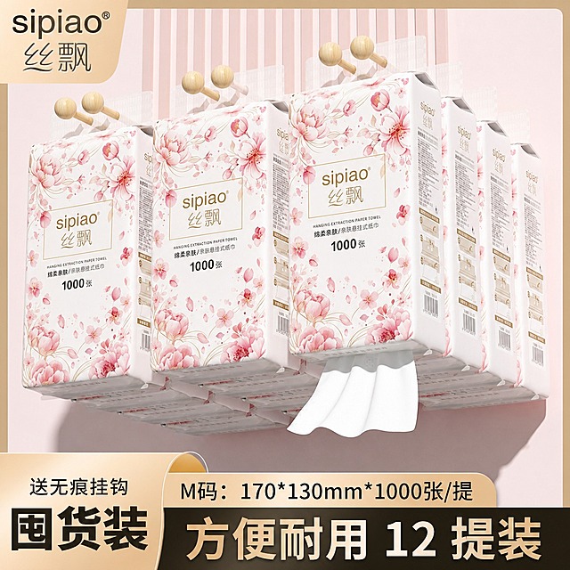 将图中所有悬挂式抽纸外包装的图案完全替换为参考图1（好忆家白底图）的樱花粉色花卉包装设计，包括粉色樱花、牡丹花、花瓣飘落的水彩风格图案，以及金色边框的品牌文字区域布局。保留原图3的场景构图、悬挂挂钩、抽出的纸巾、底部文字信息、囤货装标题和整体粉色背景环境，只替换产品外包装图案，包装上的文字内容保持原图3的'sipiao丝飘'品牌和'1000张'等文字不变，图案风格和布局完全迁移参考图1，注意包装透视角度和光影细节要自然贴合
