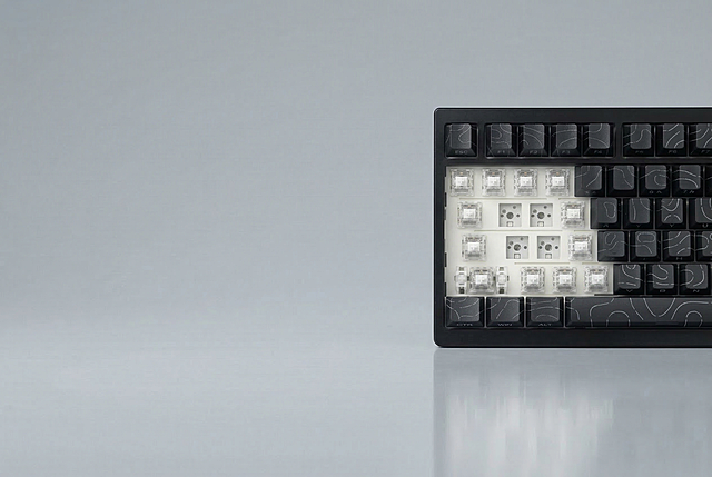 将图1右侧的白色键盘外壳替换为黑色，键帽替换为图2的黑色键帽（配浅灰色线条），保留键盘的透明轴体、缺键结构以及图1的浅灰背景、倒影与构图，整体风格协调自然，尺寸970*600像素