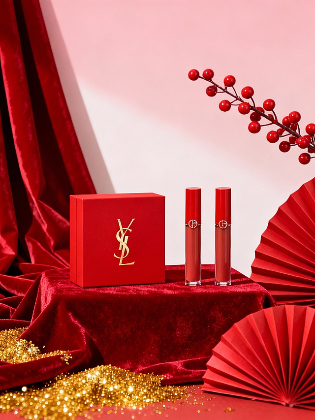 礼盒展示图
 
核心提示词：商业产品摄影，红色方形礼盒置于红色丝绒布上，盒面印有金色logo，旁边摆放两支红管唇釉，背景为浅粉色渐变墙面，装饰红色褶皱布、红色纸扇、金色闪粉和带红色浆果的枝条，整体氛围奢华喜庆，8K超高清，写实风格。