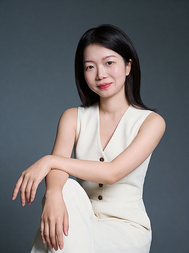 保留第一张图人物脸型､年龄特征生成标准纯正面胸像肖像照(特写);参考第二张图的人物占位和比例,头顶至上边缘有3%的距离,50mm标准焦段,人物位于画面中心,为聚焦核心,居中构图,占画面75%空间;平视视角(镜头与人物眼部平齐);入境范围头部至胸部区域,颈肩结构准确合理,姿态自然;3:4竖版中近景氛围感肖像,淡妆,肤质白皙细腻;冷调白皙,极淡裸粉哑光眼影打底,极细内眼线填充睫毛根部,大直径深棕色带细微高光点的自然款美瞳;边缘模糊无生硬轮廓;唇妆:粉调草莓红镜面水光唇釉,唇形饱满､唇峰清晰､唇面透亮光泽,唇周无晕染;身穿米白色无袖单扣v领连体裤;造型优雅干练,优雅坐姿,双臂自然交叉搭于腿面,双臂交叉搭于腿部,右手自然垂落(手指放松微张),左手轻搭右前臂,面部转向镜头,浅淡微笑,眼神直视镜头(目光坚定澄澈),表情自然､嘴角轻扬,主体锐利,美颜磨皮精致浓妆,均匀肤色提亮肤色,发质柔顺光泽,眼神直视镜头,目光坚定且澄澈,表情自然.嘴角上扬,气质自信温婉温和亲和感内敛;影棚柔和侧光(细腻明暗层次),白皙光泽+深豆沙红唇妆,高清32K细腻画质｡温柔松弛氛围;光线均匀柔和,画质清晰,表情自然,头部发型完整,去除人物之外的所有元素;美颜轻度磨皮,影棚布光(主光来自画面前方),明暗过渡柔和,背景光线均匀,强化色彩对比的高级感｡简约冷调中深灰度纯色背景(呈现均匀柔和质感),极简干净,严格按照第一张图内容生成｡